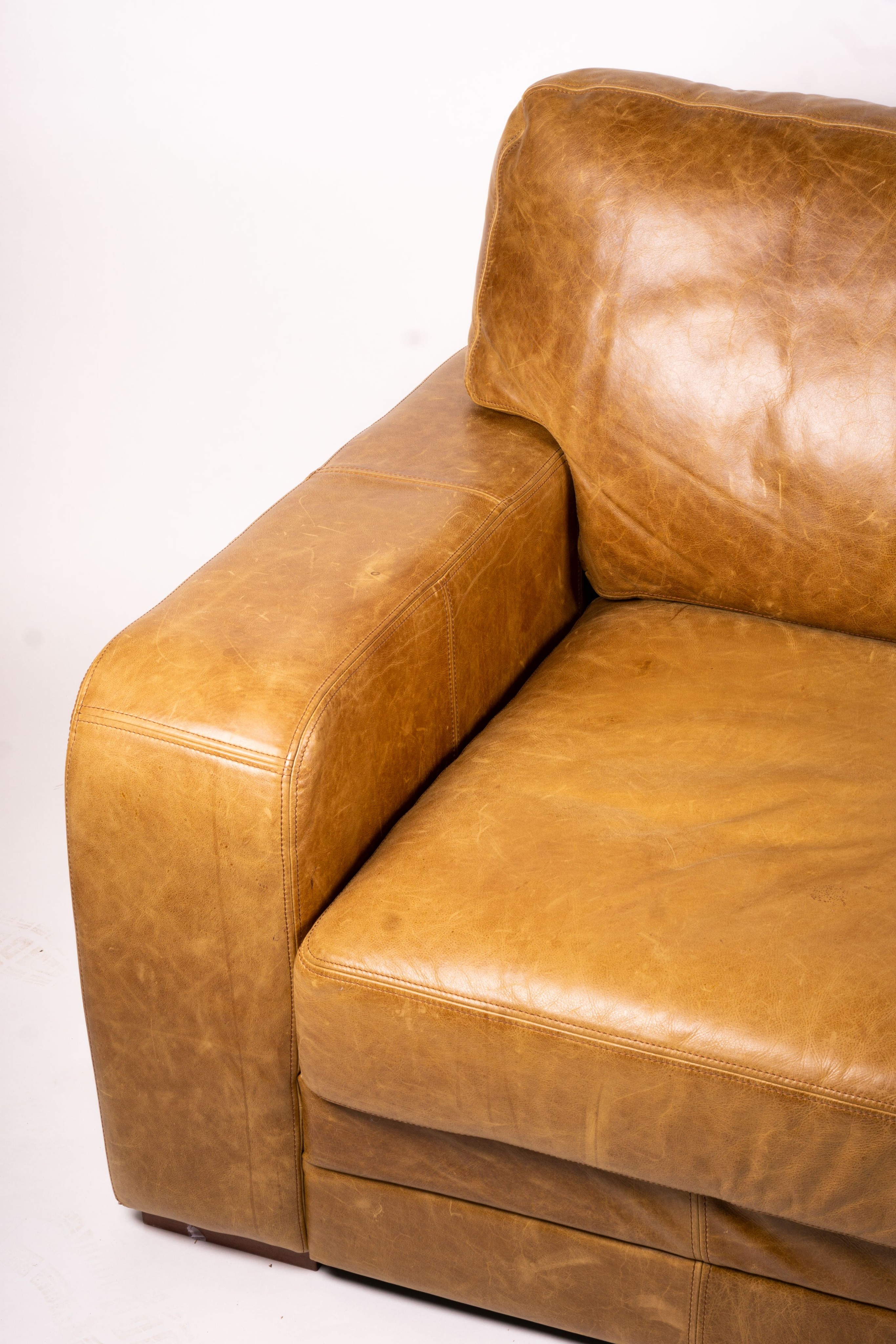 A pair of contemporary tan leather settees, length 200cm, depth 100cm, height 94cm